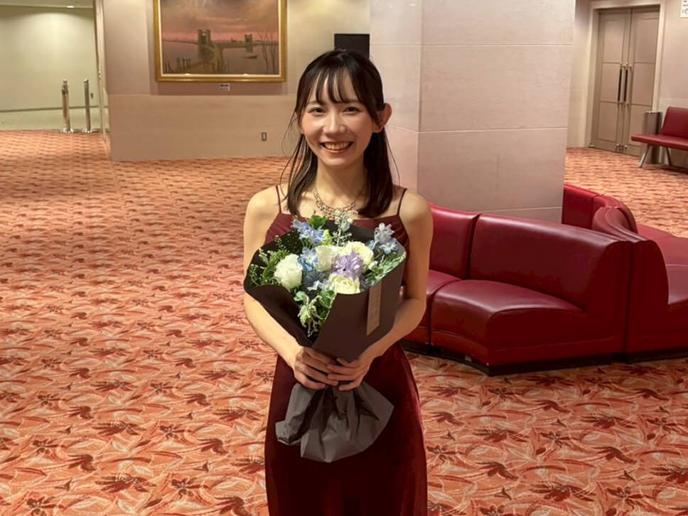 ドレス姿で花束を持っているコンクール時の様子
