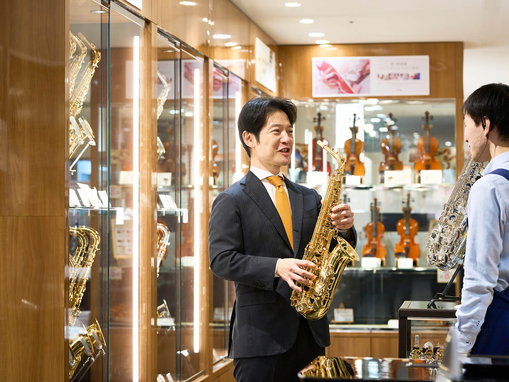 管楽器を持ちスタッフと話をしている様子