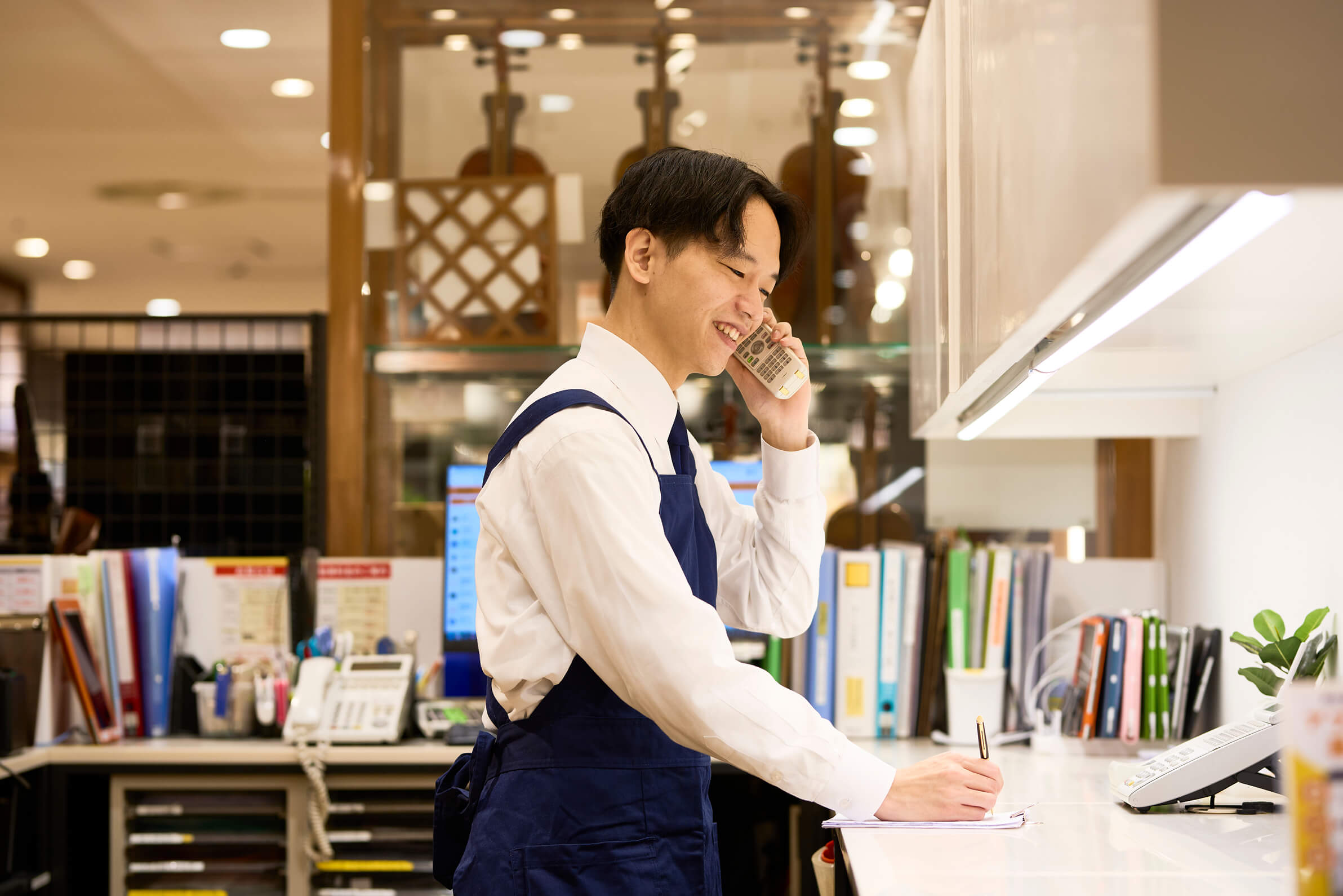 Y.N.が電話で対応をしメモを取る